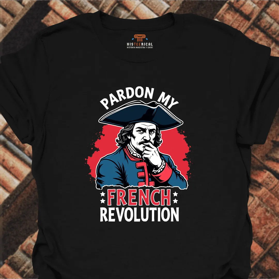 Black t-shirt with a graphic of a historical figure and text 'Pardon My French Revolution' on a brick background.