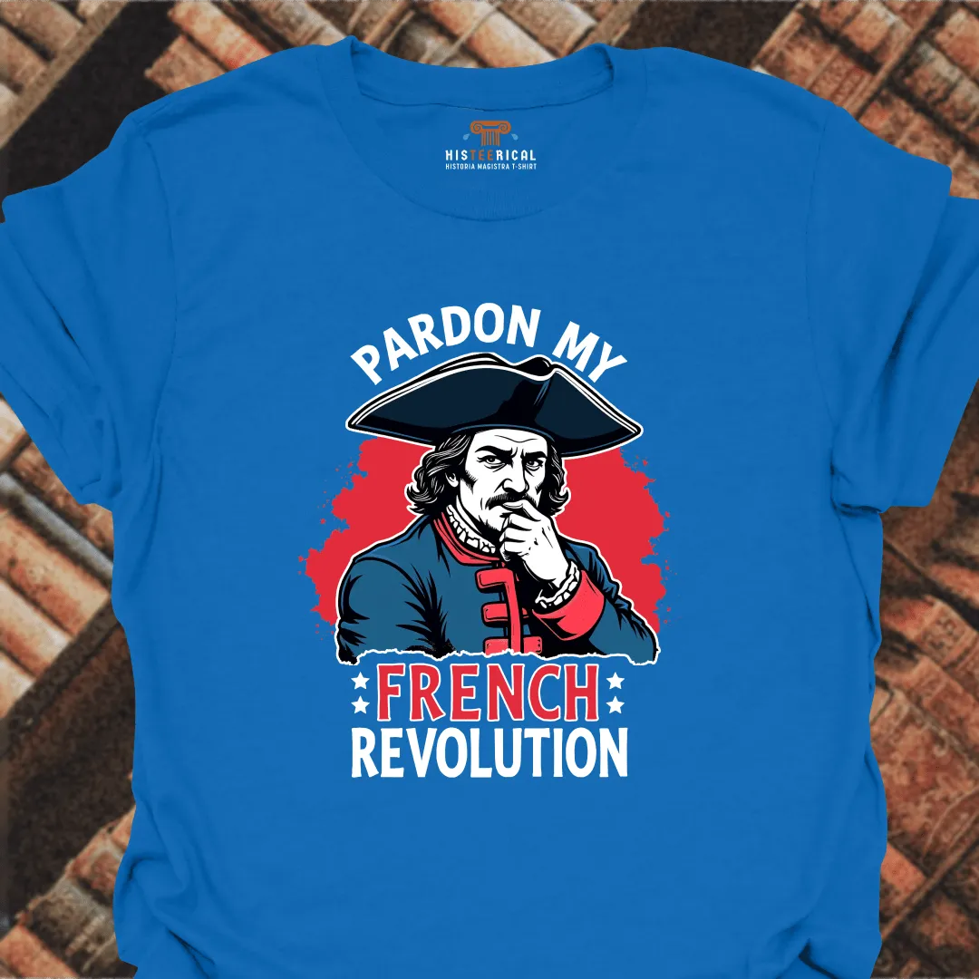 Blue t-shirt with a graphic of a historical figure and text 'Pardon My French Revolution' on a brick background.
